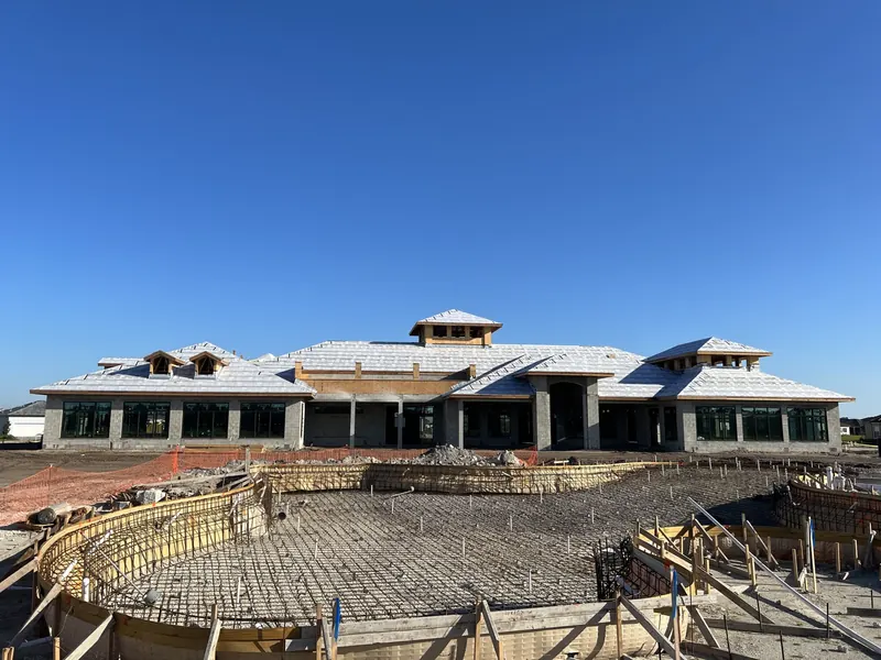 Reinforcing steel grid and timber formwork laid out across the pool footprint